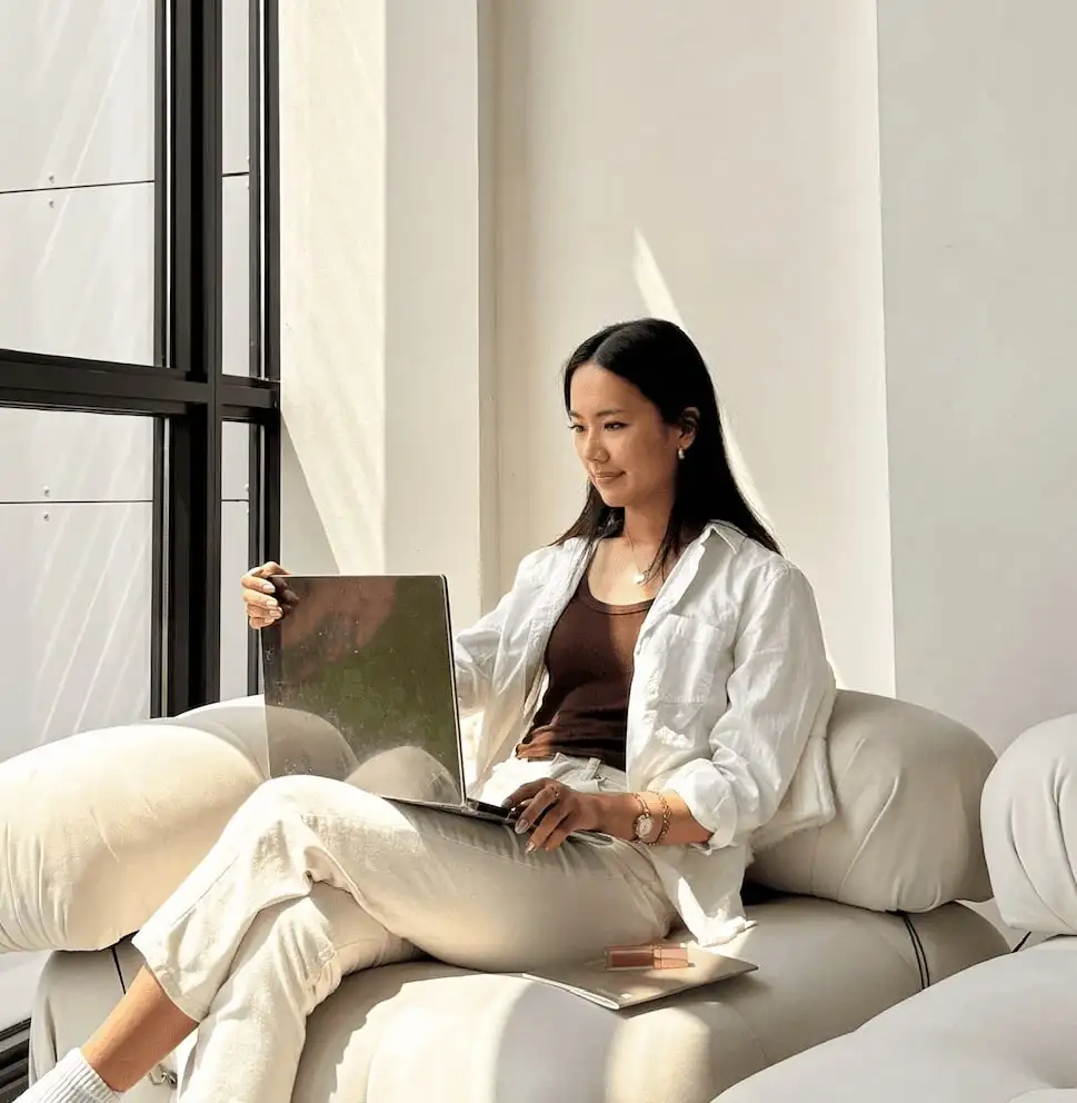 Alena Song, founder of A. Song Studio, working on a laptop in a bright studio