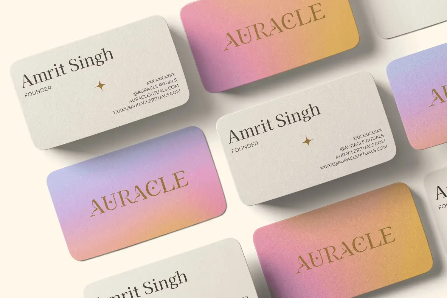 Auracle business cards: cream cards with Amrit Singh’s details and a gold star, and pink-to-gold gradient cards with the gold Auracle wordmark