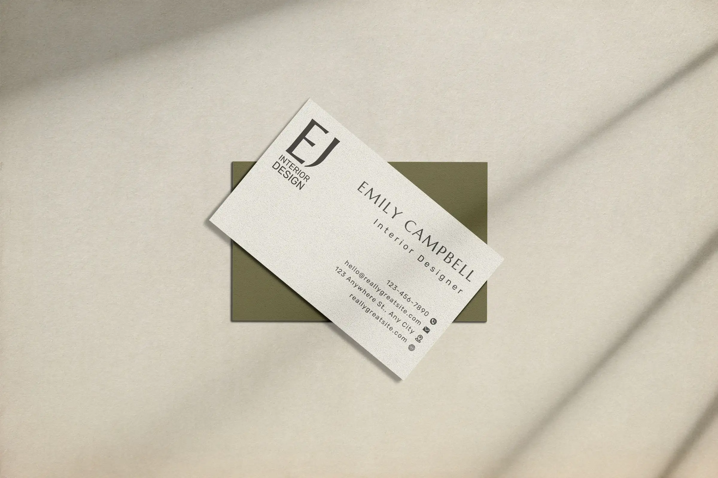Emily Campbell’s cream business card with the EJ monogram, resting on an olive card