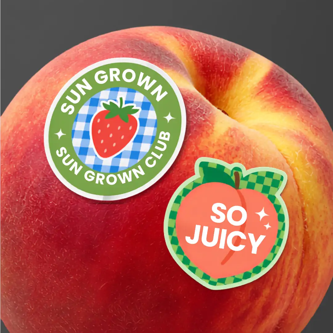 A peach wearing two produce stickers: ‘Sun Grown Club’ and ‘So Juicy’.