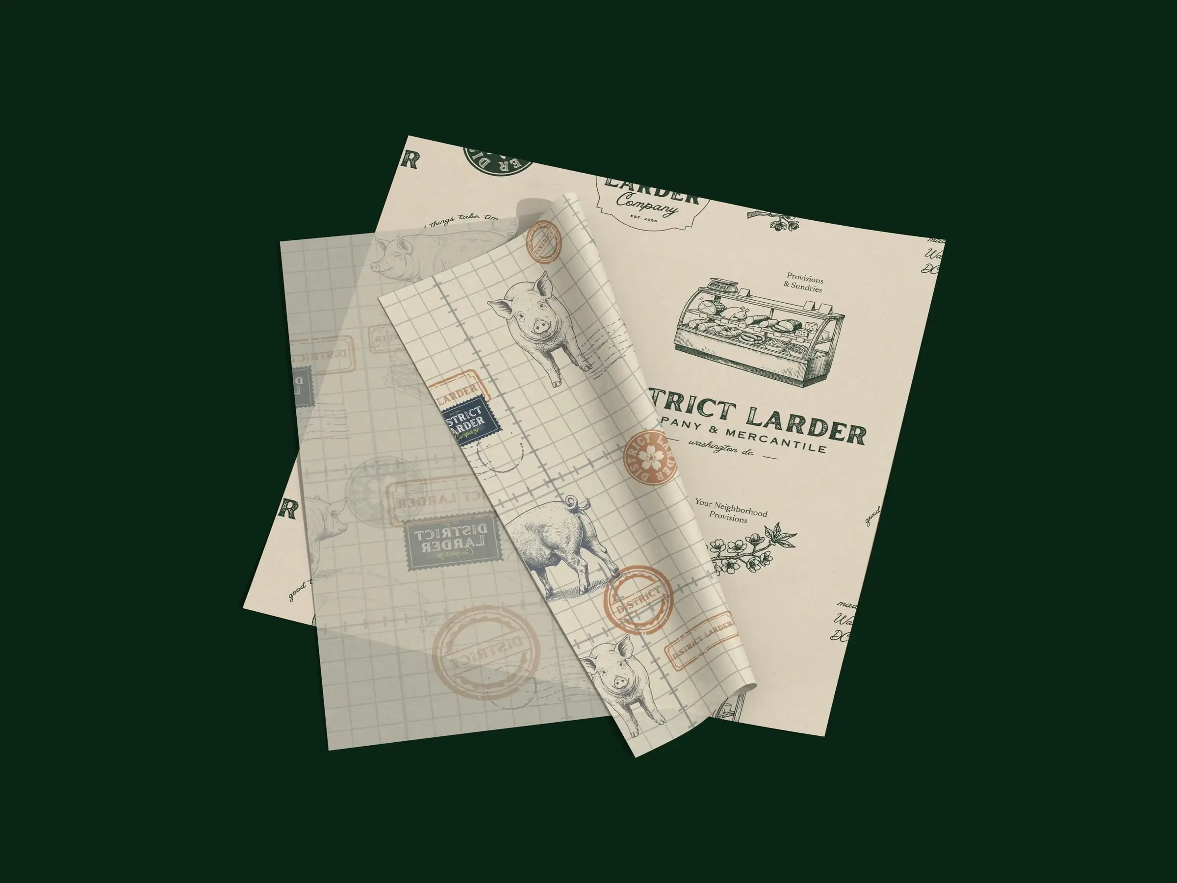 District Larder deli papers: a cream sheet with a deli-counter illustration and the wordmark, and a grid pattern of pigs and stamps