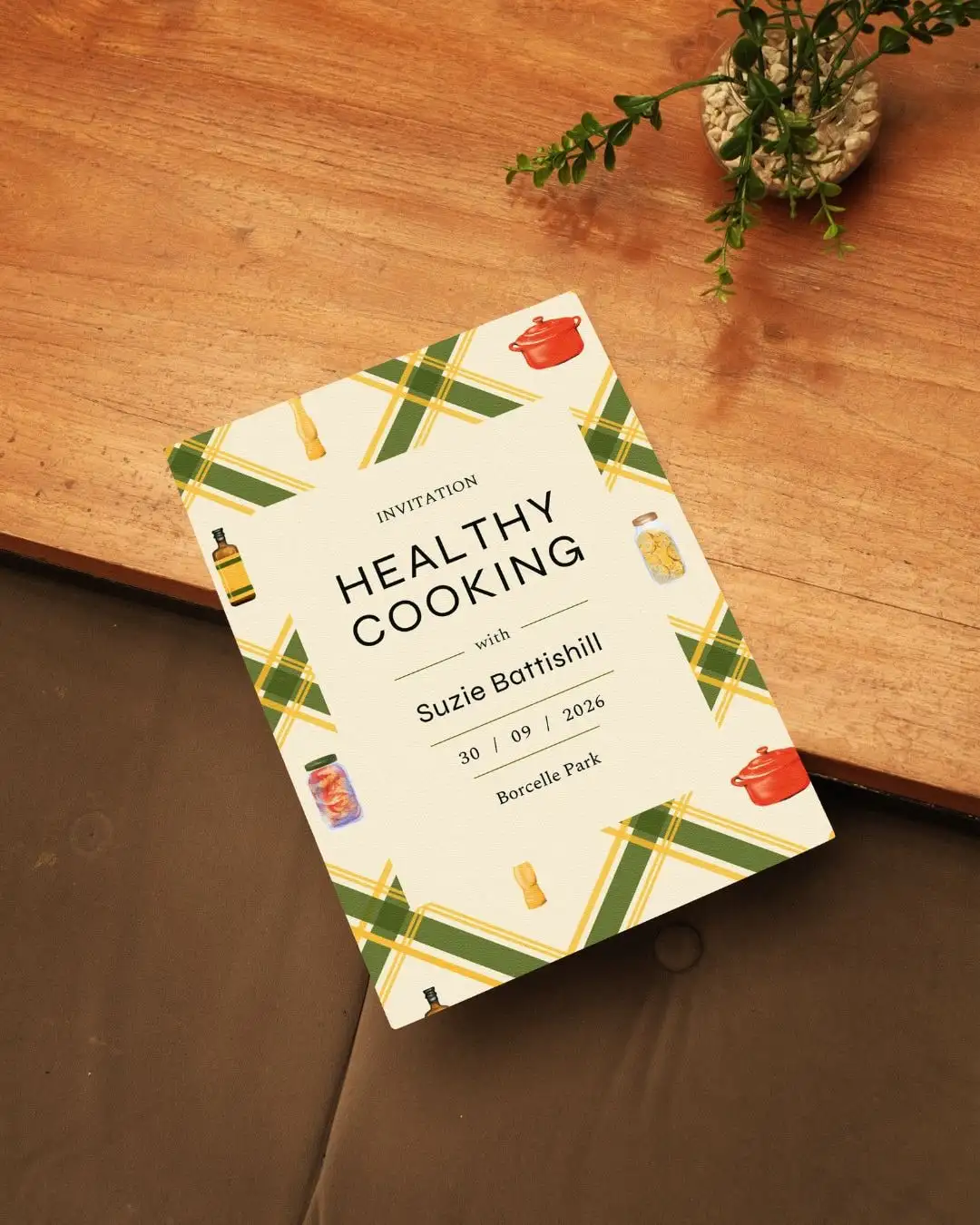 A printed “Healthy Cooking with Suzie Battishill” invitation, framed by the tartan pattern and kitchen illustrations