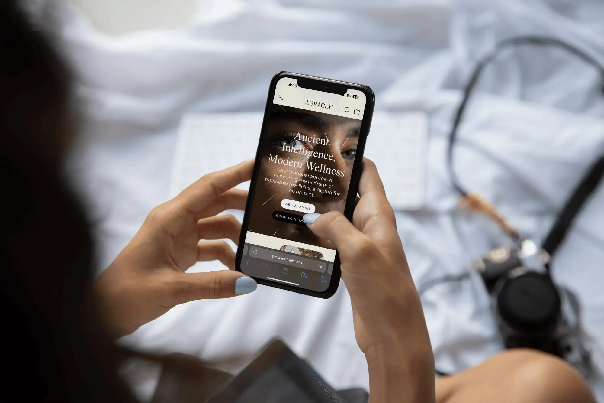 A phone showing the Auracle mobile homepage, headed “Ancient Intelligence, Modern Wellness”