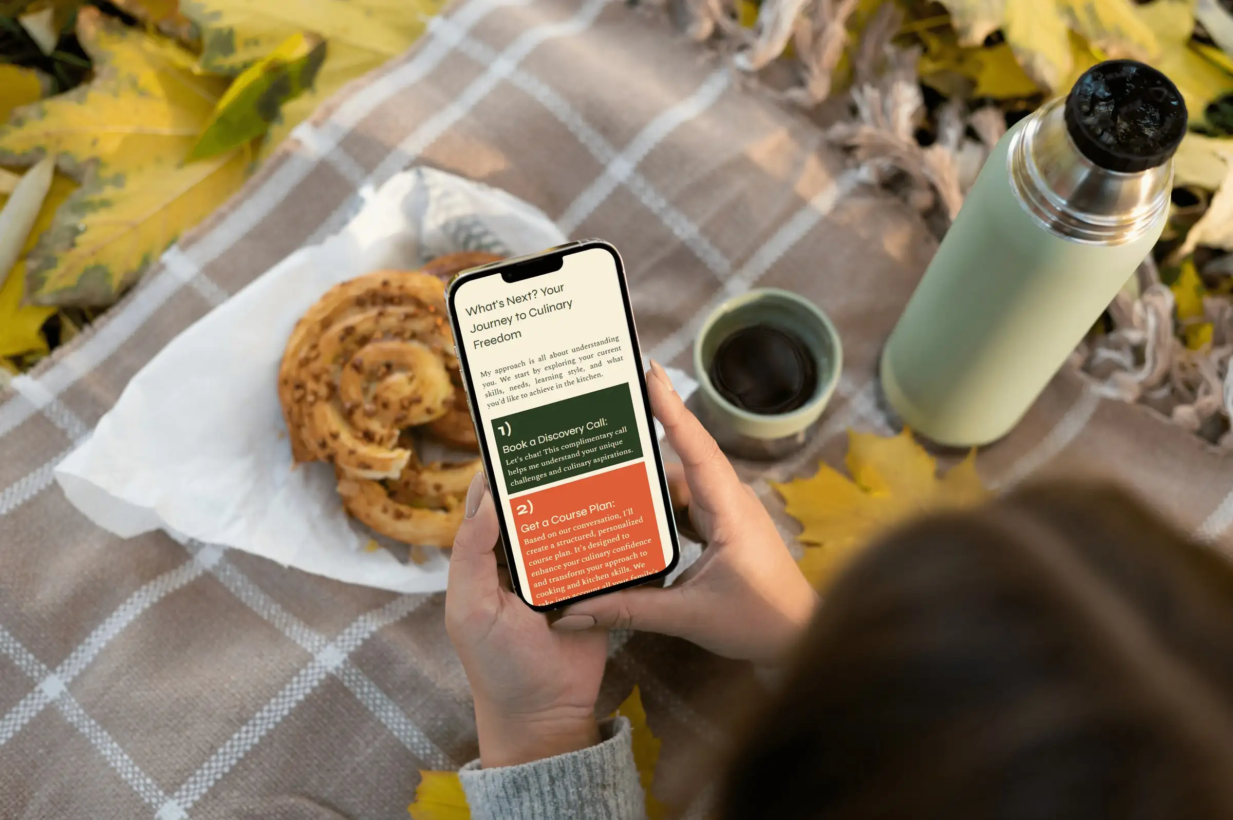 A phone showing the Suzie Battishill site’s next steps, starting with booking a discovery call